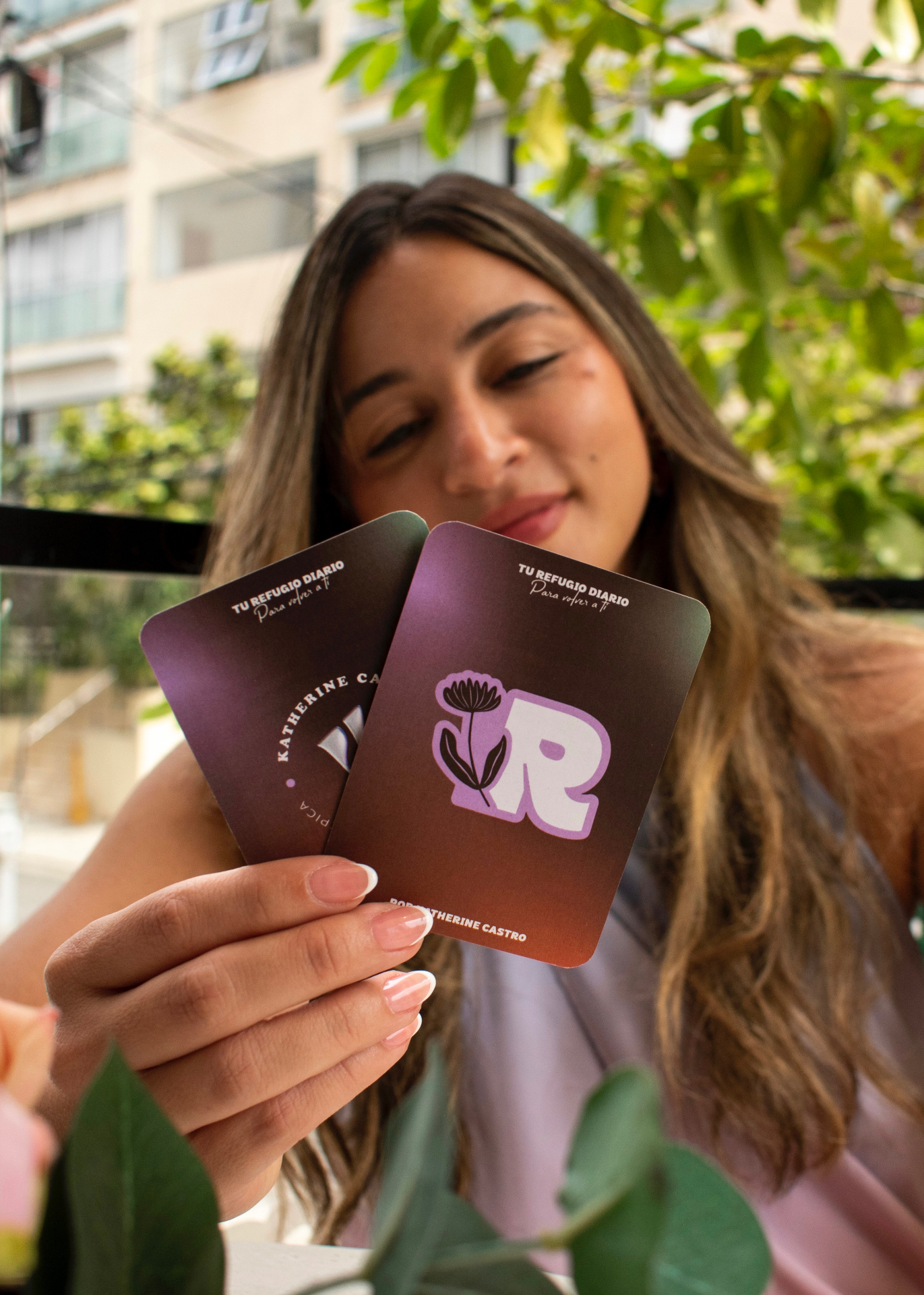 Mano sosteniendo cartas de Tu Refugio Diario